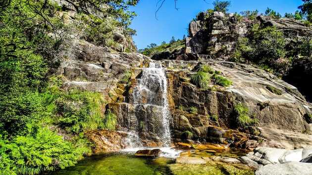 Wasserfall, der stufenweise einen massiven Felsen hinunter fällt im peneda Geres Nationalpark.