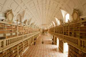 Foto der Bibliothek im Nationalpalast von Mafra. Diesen kulturellen Schatz sollten Sie sich bei Ihrem Portugal Roadtrip nicht entgehen lassen.