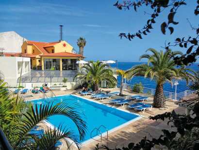 Hotel Cais da Oliveira- Außenpool mit Liegen und das Meer im Hintergrund