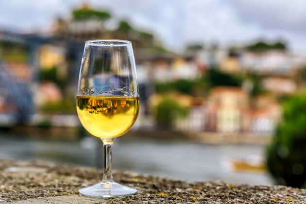 Ein Glas Portwein am Ufer des Douros während der Porto Städtereise genießen.