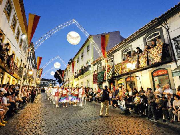 EIn Erlebnis der Azoren Rundreise mit dem Mietwagen in 21 Tagen: Festliche Atmosphäre auf der Straße von Terceira mit traditionell gekleideten Menschen.