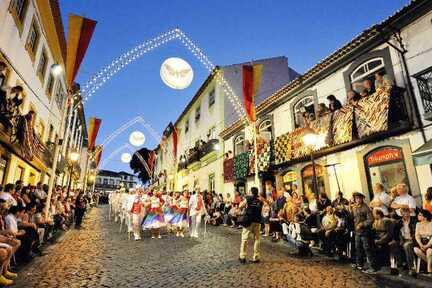 EIn Erlebnis der Azoren Rundreise mit dem Mietwagen in 21 Tagen: Festliche Atmosphäre auf der Straße von Terceira mit traditionell gekleideten Menschen.